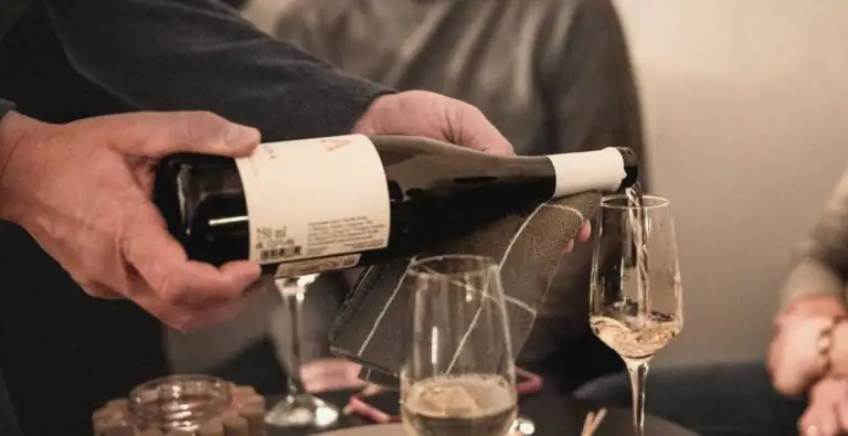 Nalewanie białego wina Winnicy Amelie do kieliszków podczas degustacji